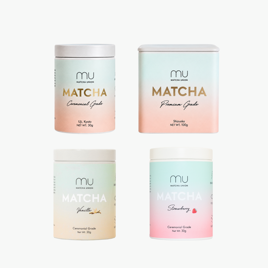 Four MU Matcha Green Tea powder containers arranged in a 2x2 grid on a light gray background. The products include Uji Kyoto Grade 1, Shizuoka Premium Grade 1, Vanilla, and Strawberry flavors, each in a pastel gradient jar with gold and white text.