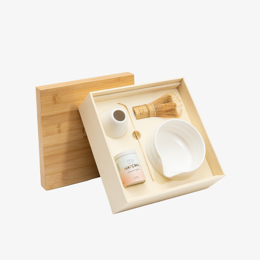 Open Matcha Union Ceremony Set with ceremonial matcha, bamboo whisk and scoop, white ceramic pouring bowl and whisk holder, beside its bamboo lid.