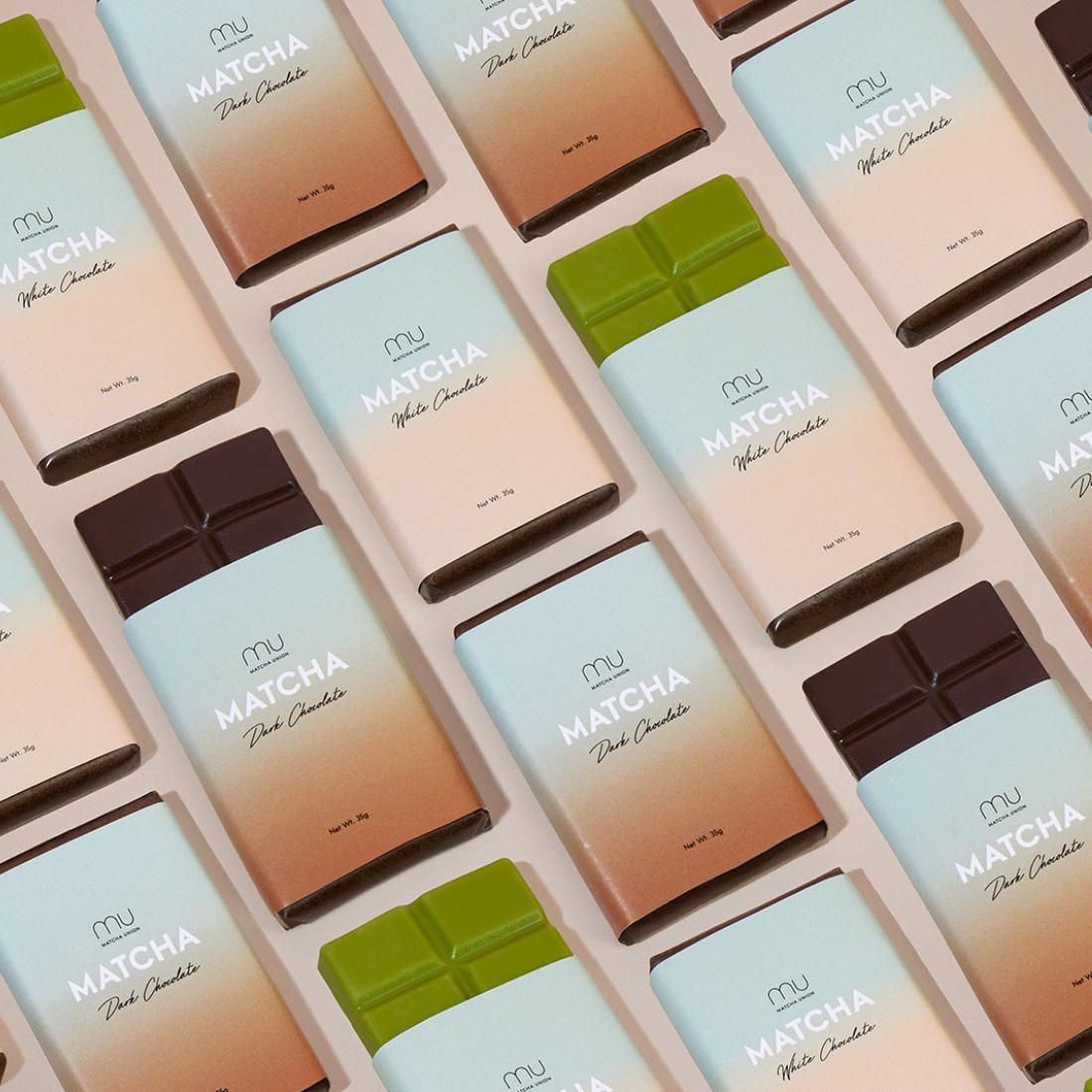 Matcha Union dark and white matcha chocolate bars arranged diagonally, with partially unwrapped bars revealing dark brown and matcha-green chocolate.