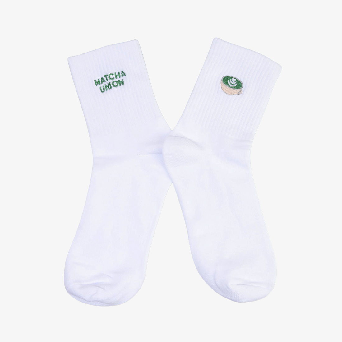Pair of white ribbed Matcha Union socks with green embroidered brand lettering on one sock and a matcha cup design on the other.